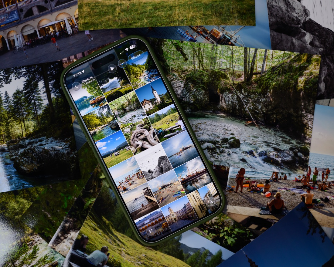 Un téléphone posé au milieu de tirages papier de photos de voyage